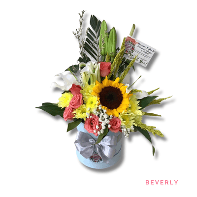 Beverly: A cheerful arrangement of sunflower, roses, casablanca, and mums, beautifully accented with baby’s breath and lush greenery.