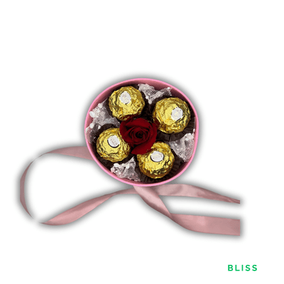 Bliss: A deep red rose surrounded by four Ferrero Rocher chocolates and delicate snow mesh, beautifully presented in pink.
