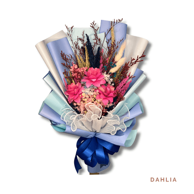 Dahlia arrangement on a plain background: Delicate bouquet of 3 vibrant pink wood flowers with dried foliage, wrapped in soft tones and finished with a sophisticated navy ribbon.