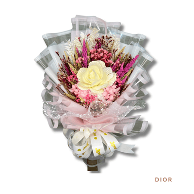 Dior arrangement on a plain background: Radiant bouquet of local peonies and pink dried blooms with textured foliage, wrapped in soft pink and white with a delicate ribbon.