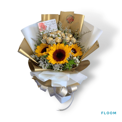 Floom arrangement on a plain background: Sweet combination of 12 Ferrero Rocher chocolates and 3 vibrant sunflowers, wrapped in elegant white and gold.