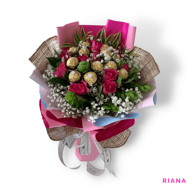 Riana arrangement on a plain background: Stunning combination of 12 pink roses and 12 Ferrero Rocher chocolates, blending beauty and indulgence.