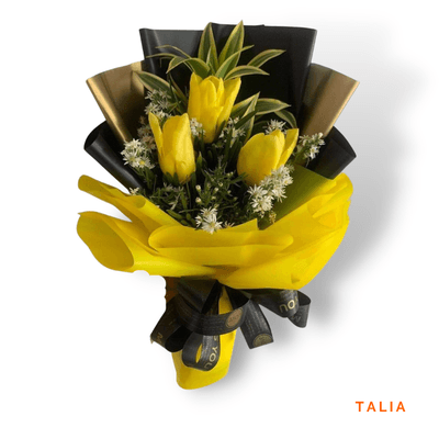 Talia arrangement on a plain background: Three radiant yellow tulips symbolizing happiness and friendship, bringing sunshine, warmth, and hope to every special moment.