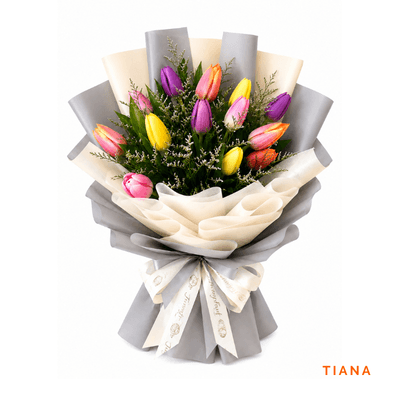 Tiana arrangement on a plain background: Twelve mixed-color tulips beautifully arranged, bringing vibrant springtime charm, freshness, and joy to every special occasion.