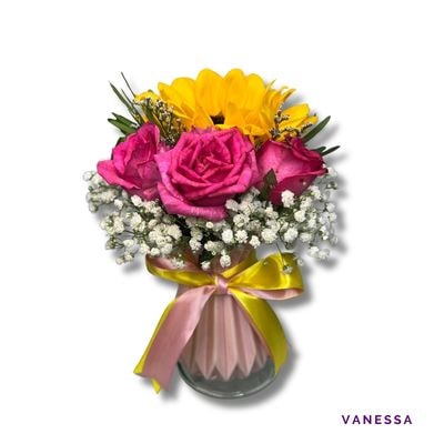 Vanessa: A charming arrangement of one radiant sunflower and six elegant roses in a 7-inch ceramic vase—bright and graceful for any occasion.