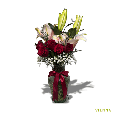 Vienna: A stunning Stargazer lily paired with six red roses, beautifully arranged in glass, symbolizing passion, love, and grace.